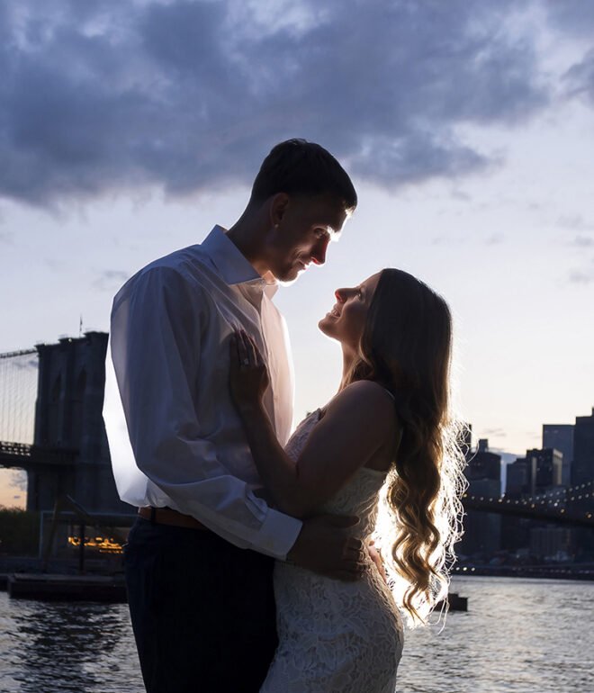 Newly engaged couple posing by the water, showcasing professional outdoor photography by Tino Photography.